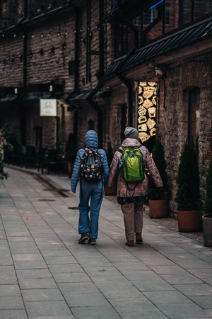 People walking down dark pedestrian alleway in the center of Tallinn, Estoniaの写真素材