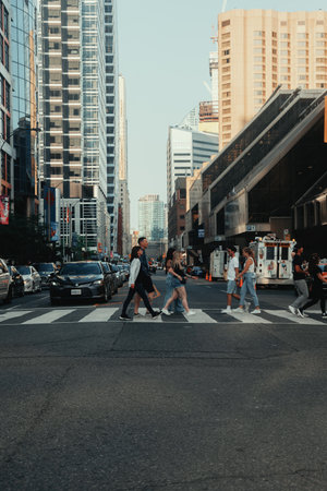 People crossing the street in downtown Toronto. Ontario on sunny dayの写真素材