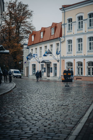 People walking down old town street past Finnish embassy in Tallinn, Estoniaの写真素材