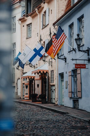 Flags hanging off building on old town street in Tallinn, Estoniaの写真素材