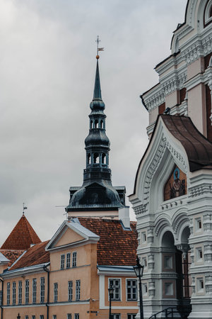 Church spire above old yellow buildings in the old town in Tallinn, Estoniaの写真素材