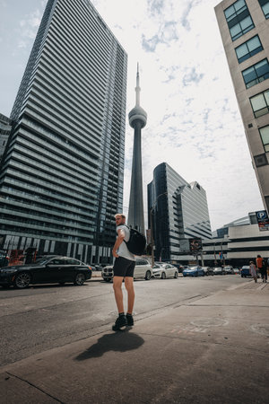 Man walking down street towards the CN Tower in Toronto, Ontarioの写真素材