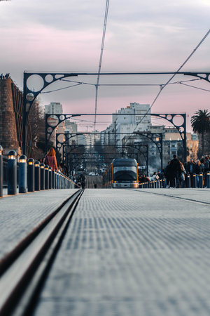 Pink sunset sky above tram on Dom Luis I bridge in Porto, Portugal