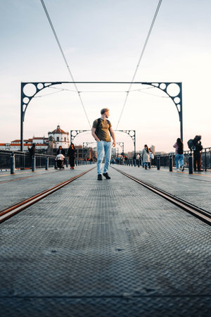 Man walking on top of Ponte Dom Luis I bridge in Porto, Portugalの写真素材