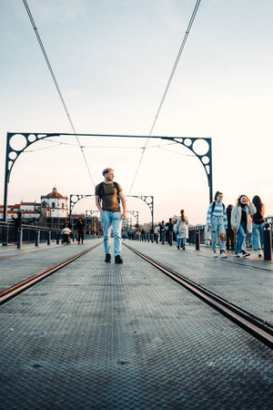 Man walking between tram lines on top of Ponte Dom Luis I in Porto, Portugal