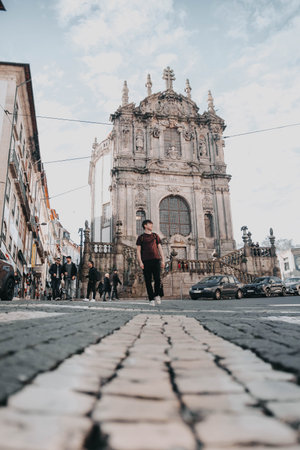 Man walking down road in front of Clerigos Church in Porto, Portugal