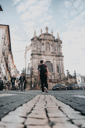 Man walking towards Clerigos Church on sunny day in Porto, Portugalの写真素材