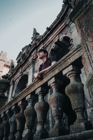 Man on sunny day looking over the balcony of the Cathedral of Porto, Portugalの写真素材