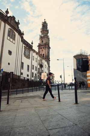 Man walking on street under the Clerigos Tower in Porto, Portugalの写真素材
