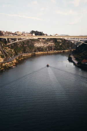 Boat on the River Douro sailing under road bridge in Porto, Portugalの写真素材