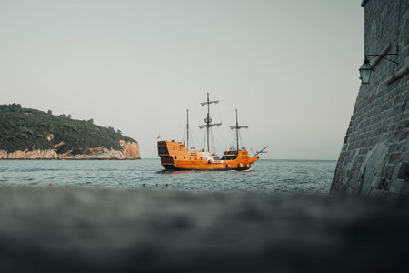 Old wooden pirate ship on the sea outside Dubrovnik old town city wall, Croatiaの写真素材