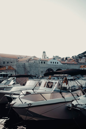 Small boats in Dubrovnik harbour with the old town in the background, Croatiaの写真素材