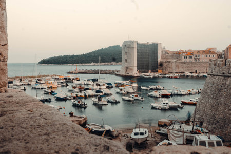 Boats in Dubrovnik old town harbour at sunset, Croatiaの写真素材