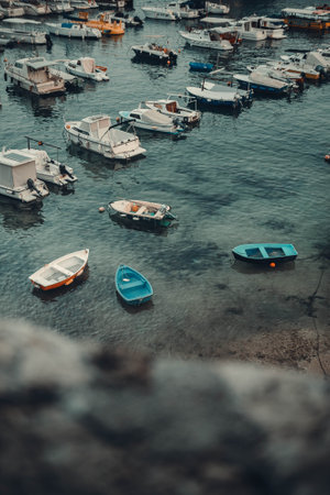 Boats in shallow sea water outside Dubrovnik old town harbour, Croatia, sunsetの写真素材
