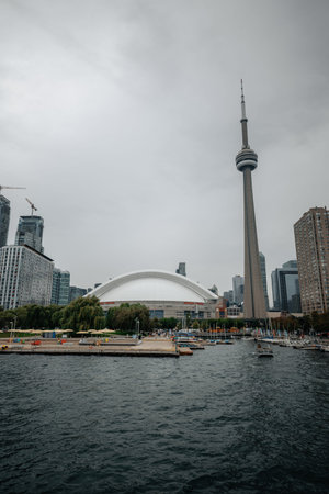 Rogers Centre next to CN Tower on cloudy day, shot from Lake Ontario, Toronto
