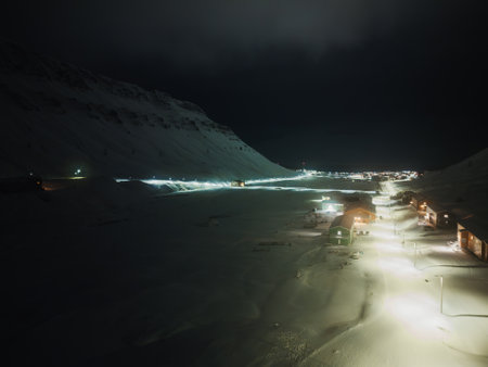 Drone shot of Nybyen and snowy valley of Longyearbyen at nightの写真素材