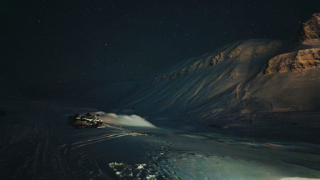 Snowmobiles in starry polar night in snowy valley in Longyearbyen, Svalbard