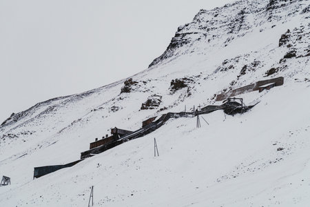 Abandoned coal mine on mountainside in Longyearbyen, Svalbard in the snowの写真素材
