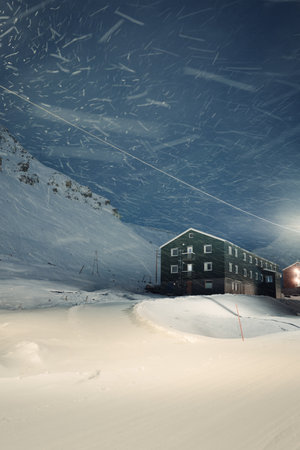 Snowing on cabin under mountain in Longyearbyen, Svalbardの写真素材