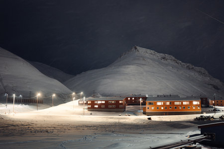Apartment blocks and streetlights under snowy mountain in Longyearbyen, Svalbardの写真素材