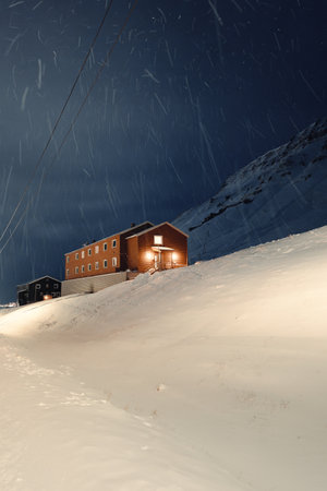 Miners cabin building in the snow at night in Nybyen, Longyearbyen, Svalbardの写真素材