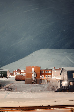 Colorful apartment blocks under snowy mountain in Longyearbyen, Svalbardの写真素材