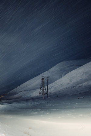 Snowing on aerial tramway tower on mountain in Longyearbyen, Svalbardの写真素材