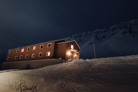 Brown wooden cabin on snowy hillside in Longyearbyen, Svalbardの写真素材