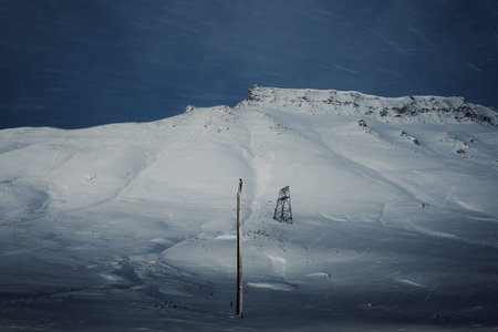 Wooden aerial cableway tower on snowy mountain in Longyearbyen, Svalbardの写真素材