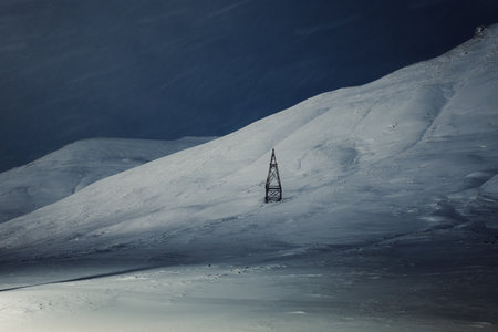 Wooden aerial tramway tower on snowy mountain in Longyearbyen, Svalbardの写真素材