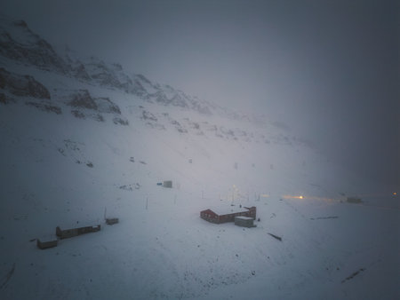 Buildings underneath mountain in winter in Longyearbyen, Svalbard, aerial viewの写真素材