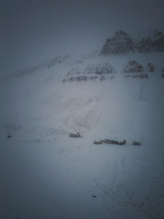 Snowy buildings under mountain in Longyearbyen, Svalbard drone shotの写真素材