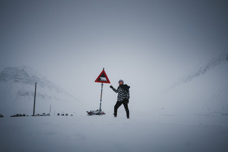 Man pointing to polar bear warning sign in Longyearbyen, Svalbardの写真素材