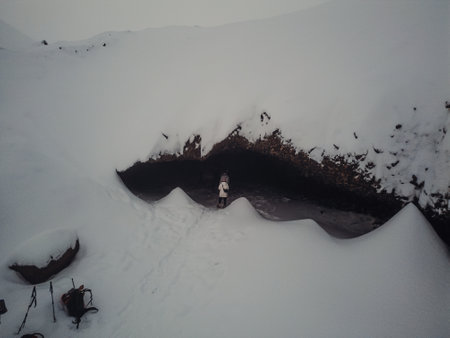 People walking into snowy mountainside cave in Longyearbyen, Svalbardの写真素材
