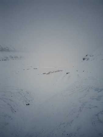 Drone shot of Longyearbyen, Svalbard from between snowy arctic mountainsの写真素材