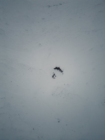 Aerial shot of cave in the snow on arctic mountain in Longyearbyen, Svalbardの写真素材