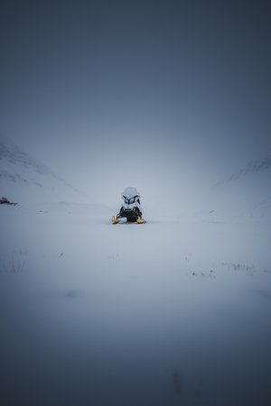 Snowmobile parked on snowy frozen arctic river valley in Longyearbyen, Svalbardの写真素材