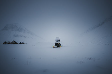 Snowmobile parked on snowy frozen arctic river in Longyearbyen, Svalbardの写真素材