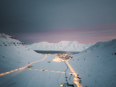 Drone shot of Longyearbyen Svalbard next to fjord under pink sky in snowy winterの写真素材
