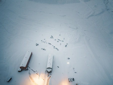 Snowmobiles parked by snowy buildings in winter in Longyearbyen, Svalbardの写真素材