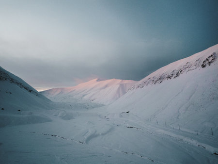 Snowy valley at sunset in the arctic mountains outside Longyearbyen, Svalbardの写真素材