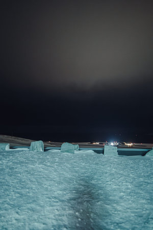 Rocks in the snow at night at the edge of car park in Longyearbyen, Svalbard
