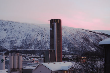 Factory chimney in the center of Tromso, Norway at sunset in winterの写真素材