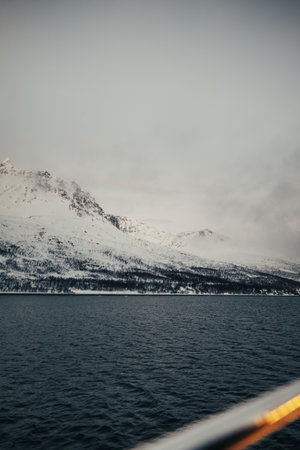 Landscape snowy mountains shot from boat on the arctic ocean, northern Norwayの写真素材