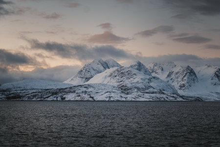Landscape shot of snowy Lyngen Alps mountains by the arctic ocean, Norway winterの写真素材