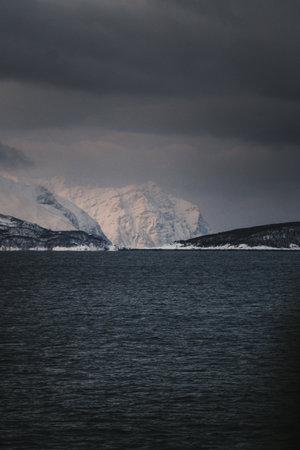 Snowy mountains in the distance by arctic ocean in northern Norway in winterの写真素材