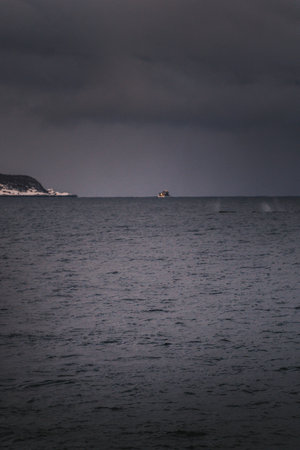 Boat on the arctic ocean under heavy grey clouds in northern Norwayの写真素材