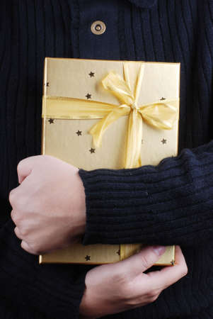 golden gift box in handsの写真素材