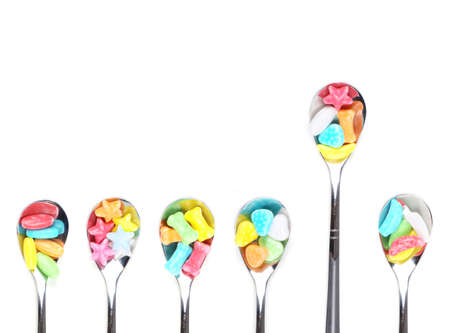 Colorful candy with metal spoonsの写真素材