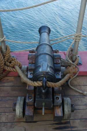 An old 18th century naval cannon on the deck of a sailing shipの写真素材